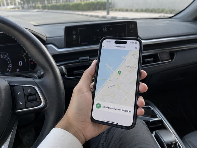 Driver sharing their Dubai location by phone from inside a parked car