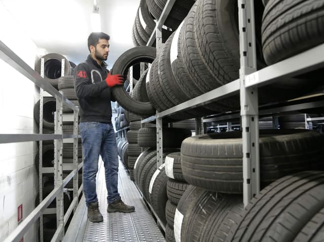 Technician selecting tyres from stocked shelves